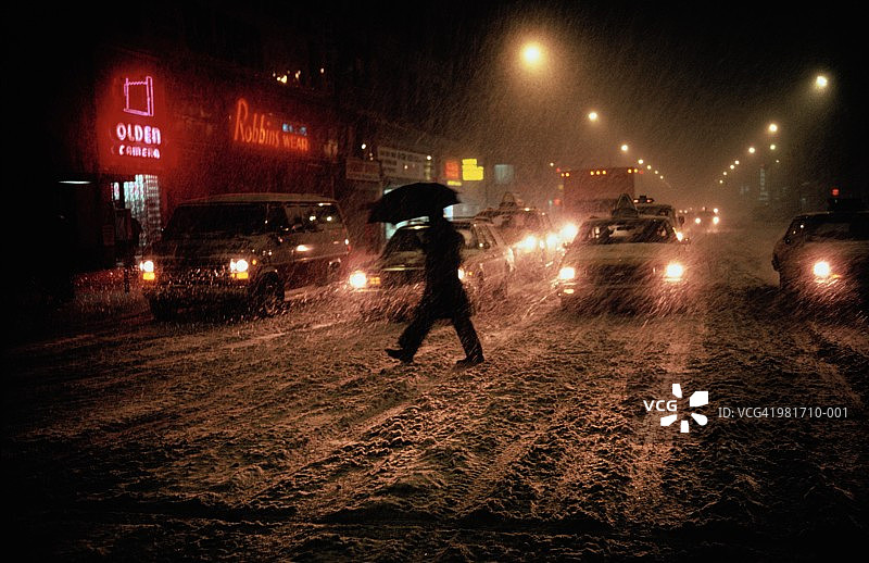 在纽约雪街打伞的男人图片素材