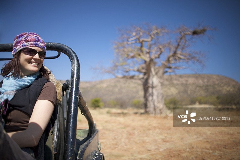 年轻女子坐在汽车里，背景是猴面包树，库内内河流域，卡奥科兰，纳米比亚图片素材
