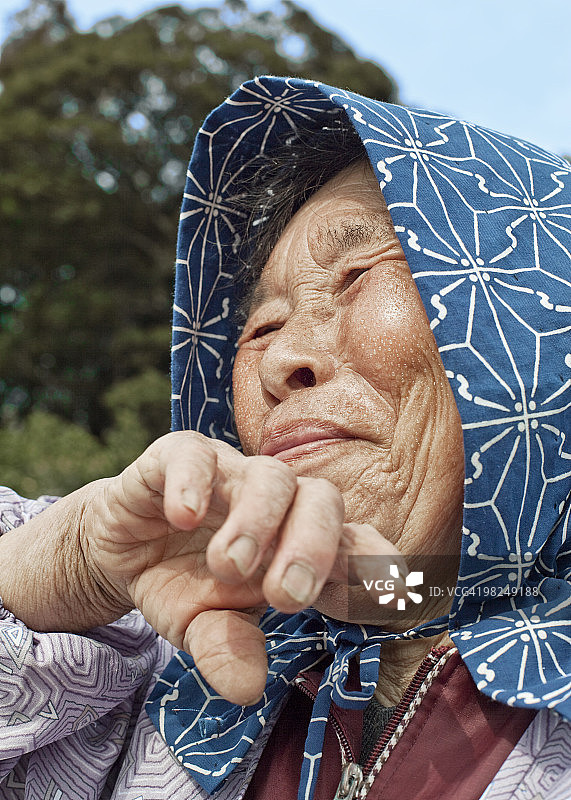 工作后擦汗的老妇人图片素材