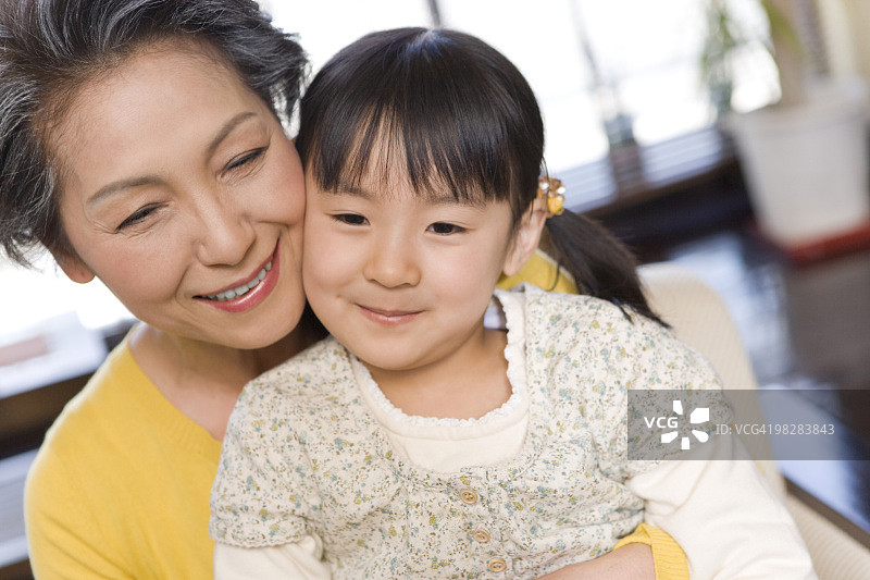 年长的女人拥抱孙女，面带微笑图片素材