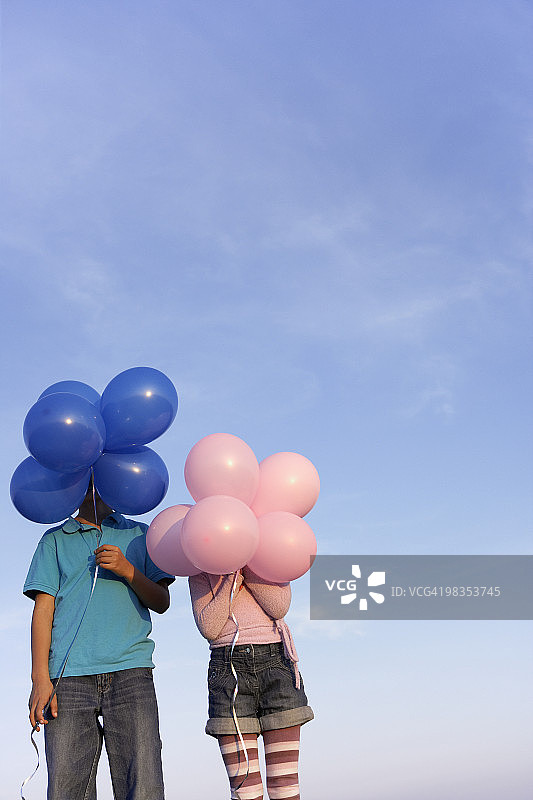 两个孩子躲在气球后面图片素材