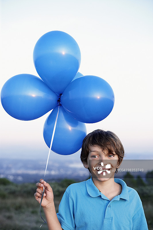 微笑的男孩拿着氦气球图片素材