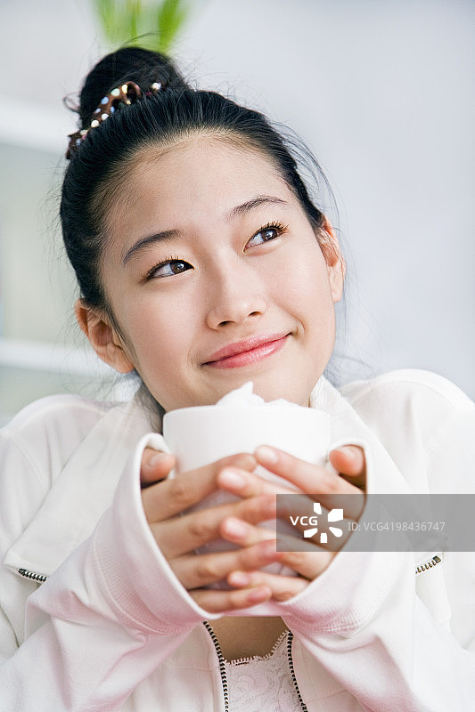 手 holding 杯子的年轻日本女孩肖像图片素材