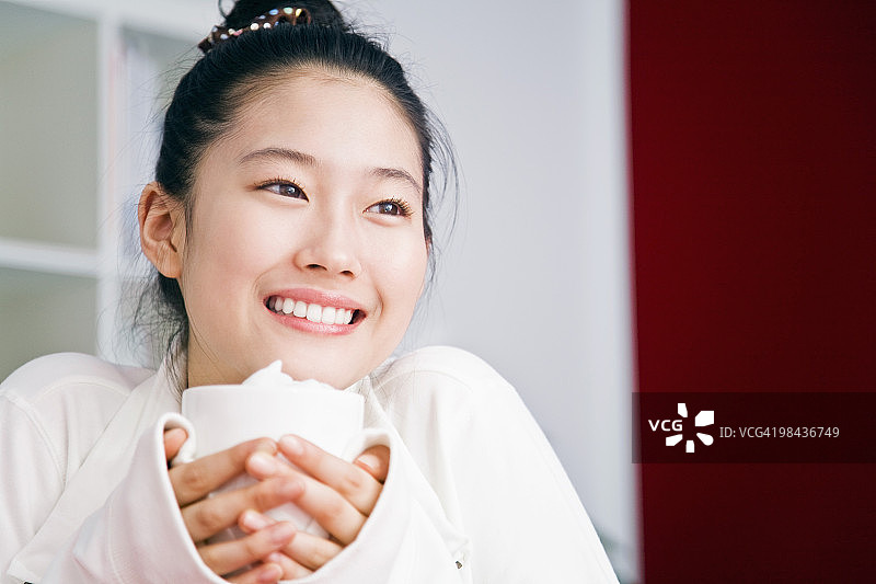 手 holding 杯子的年轻日本女孩肖像图片素材
