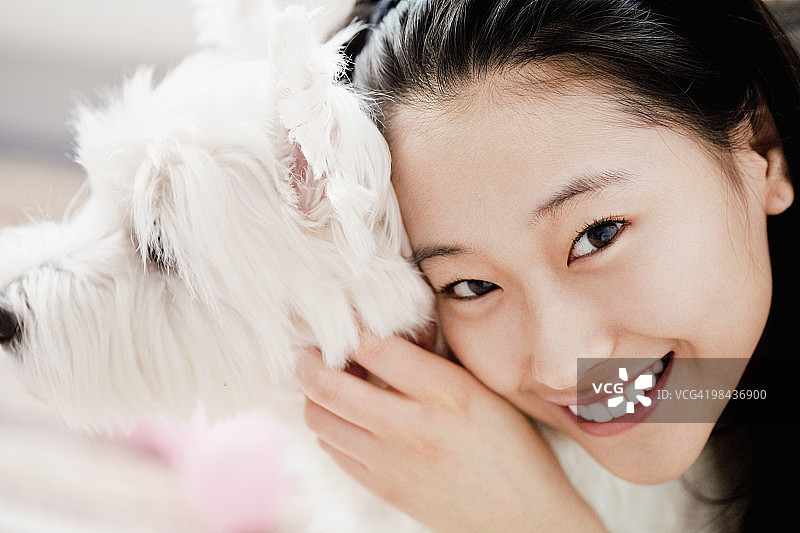 年轻日本女孩与西高地白梗犬肖像图片素材