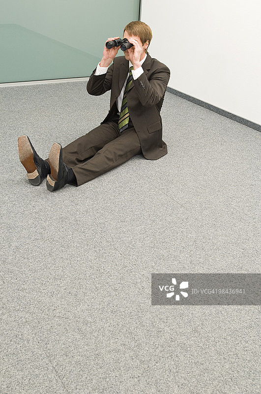 商人在角落里用望远镜看图片素材