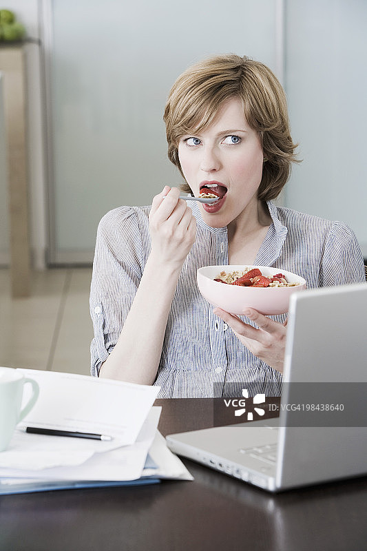 在家电脑前吃零食的女人肖像图片素材