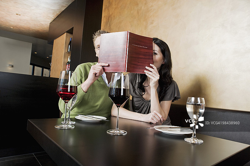 年轻夫妇在餐厅一起看菜单图片素材