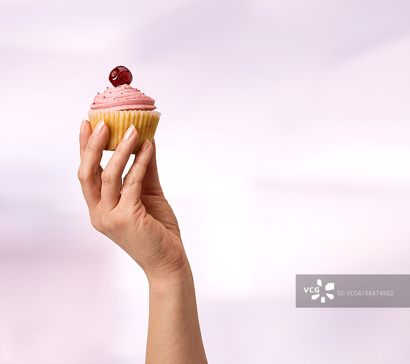 高举的樱桃纸杯蛋糕图片素材
