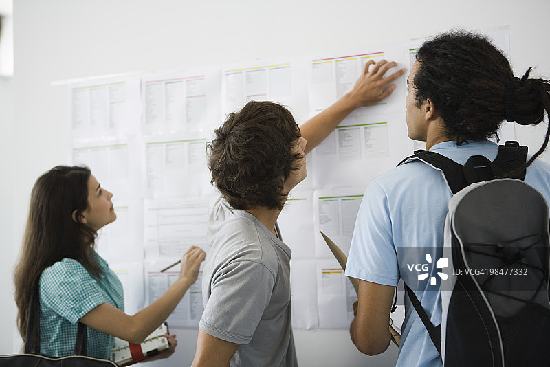 学生查看公告栏上的新课程表图片素材