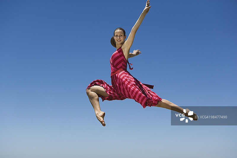 年轻女子在半空中跳跃图片素材