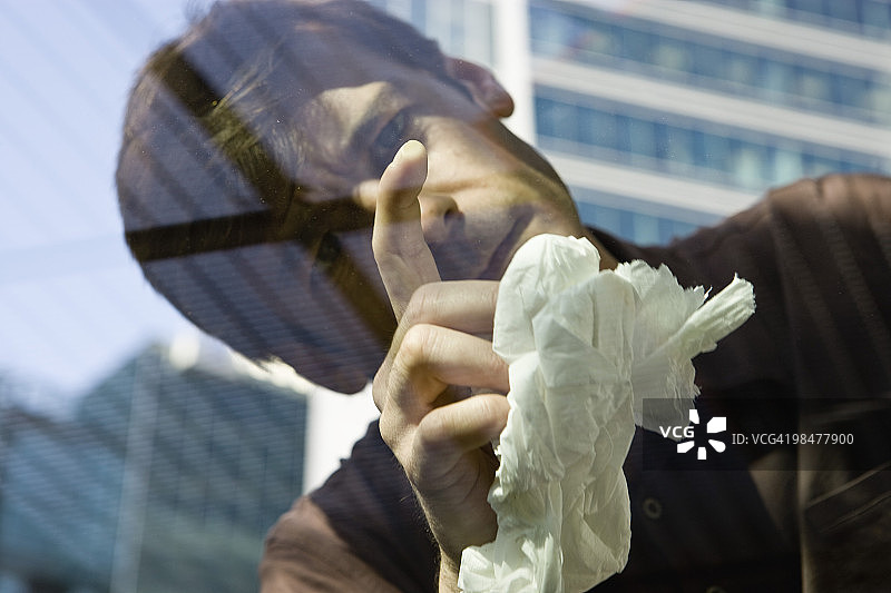 男人检查汽车车窗玻璃上的污渍图片素材