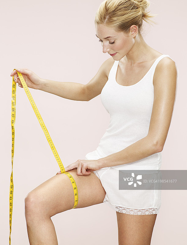 女人测量大腿尺寸图片素材