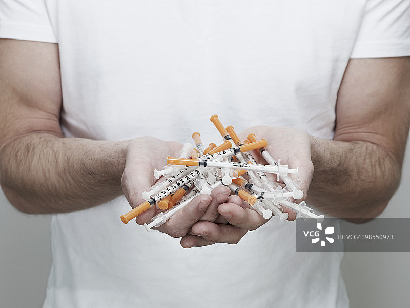 男人拿着许多胰岛素注射器图片素材