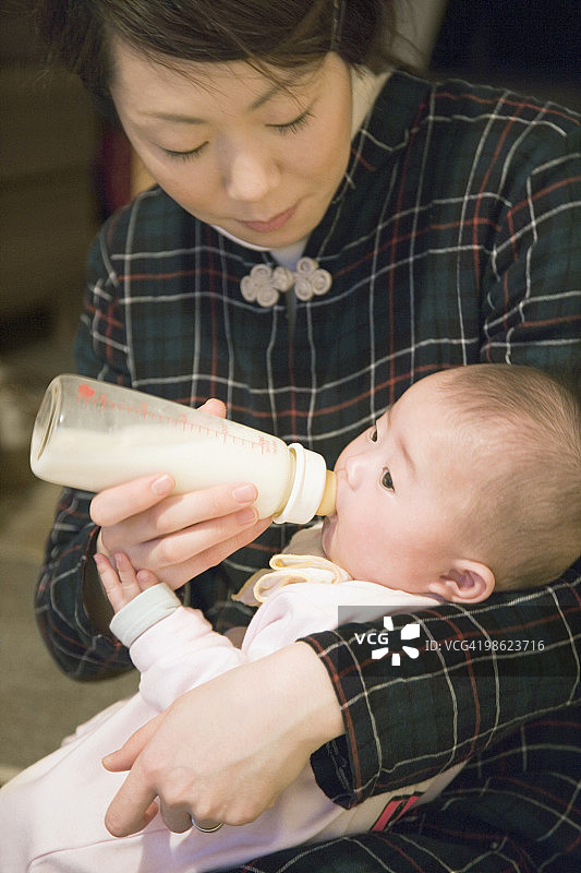 女人奶瓶喂养婴儿图片素材