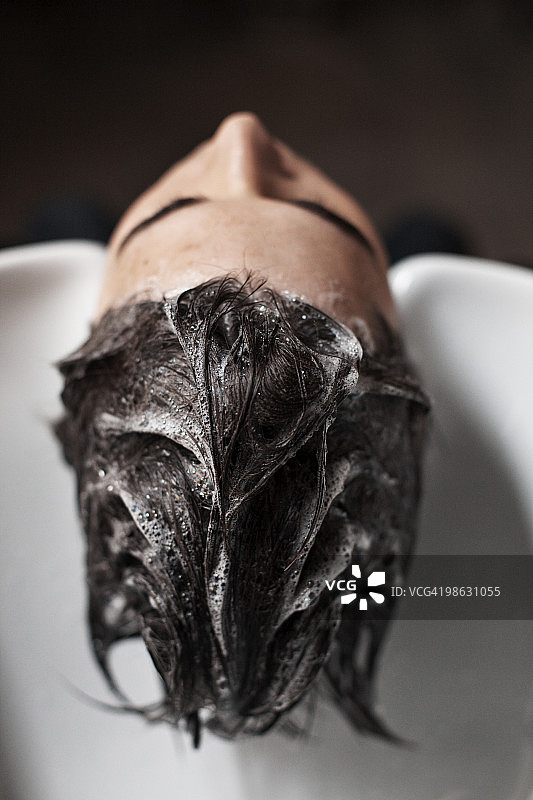 男人在理发店的水池里洗头图片素材