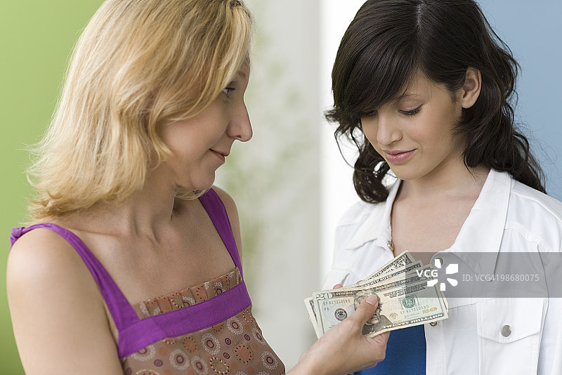 母亲给十几岁的女儿零花钱图片素材
