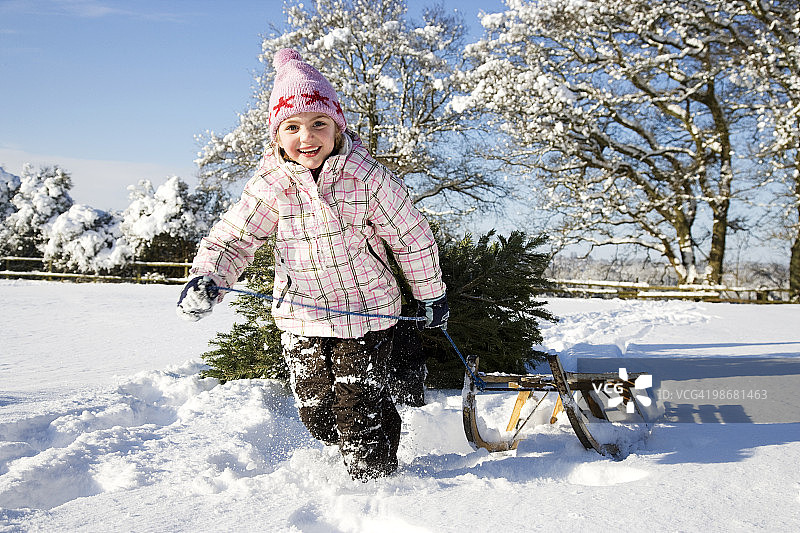 女孩在雪地里拉雪橇图片素材