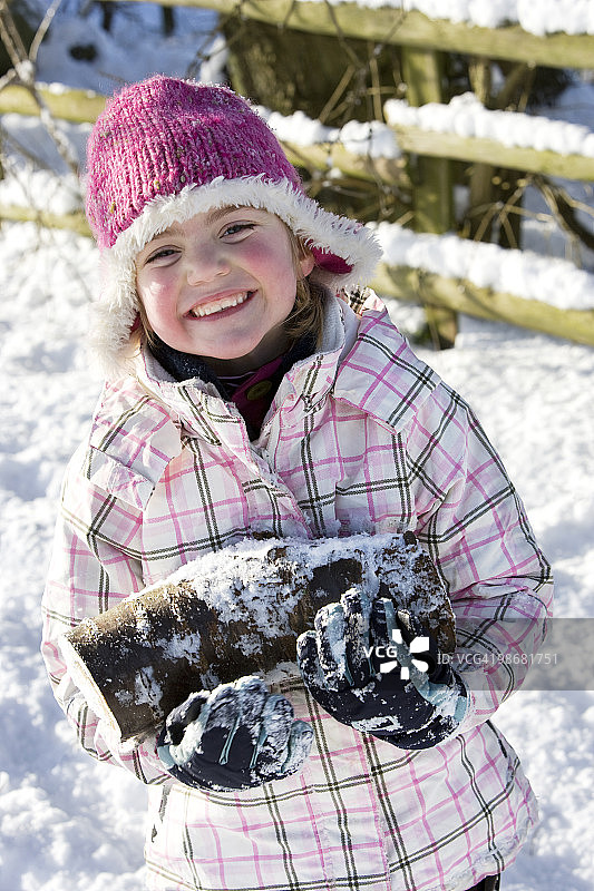 雪地里扛木头的年轻女孩图片素材