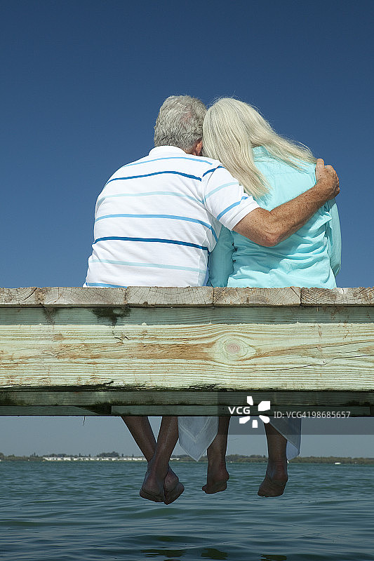 依偎在船坞上的老年夫妇图片素材