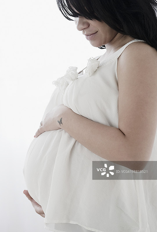 怀孕的西班牙裔女人手扶肚子图片素材