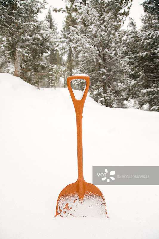 雪地里的橙色铲子图片素材