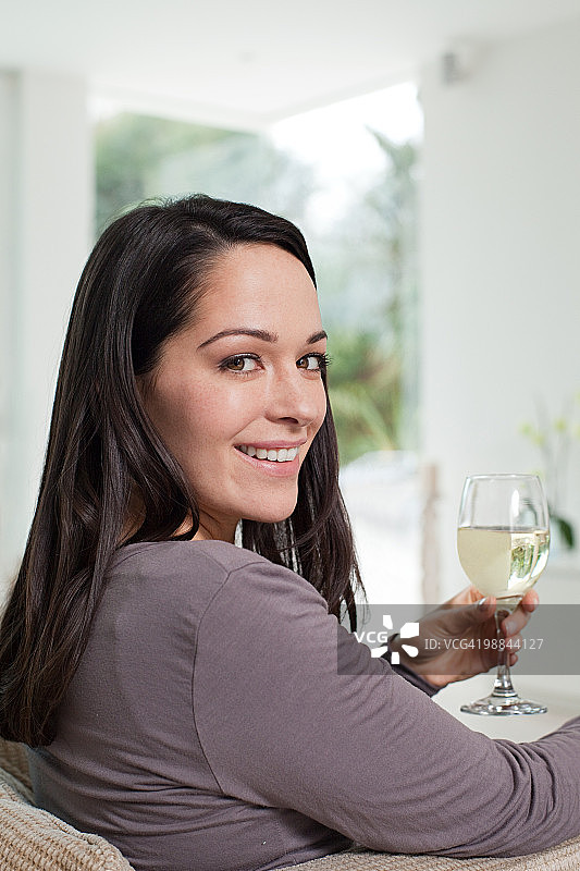 手持一杯葡萄酒的年轻女人图片素材