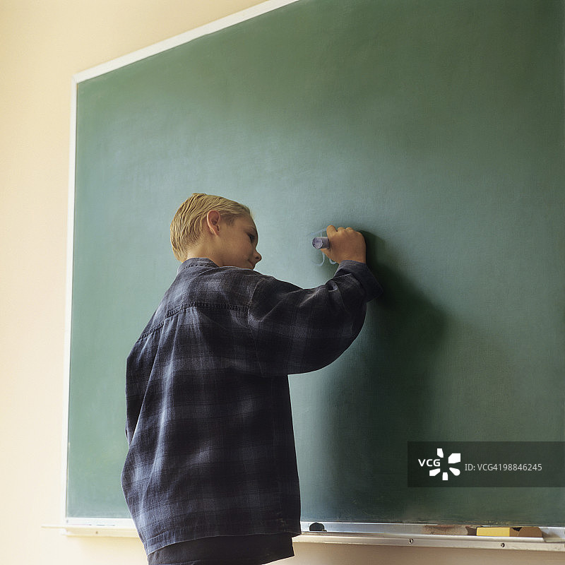 男孩在黑板上写字图片素材