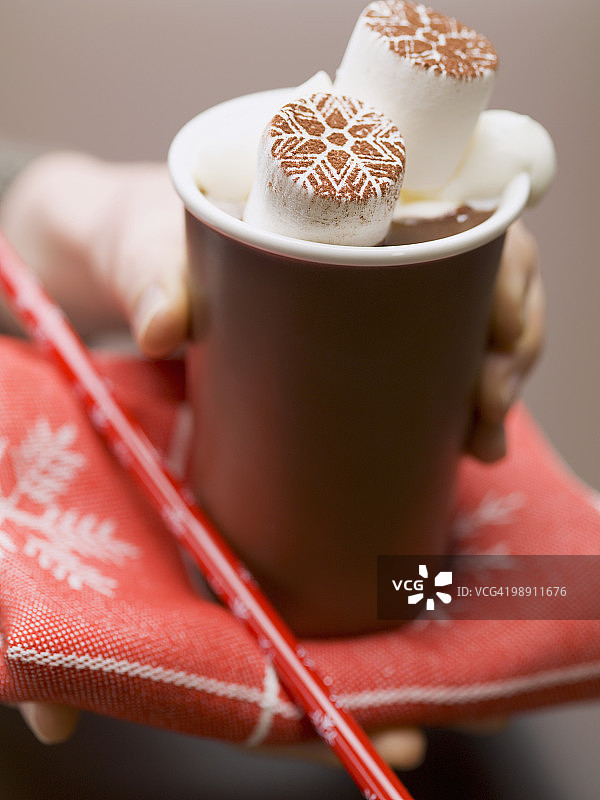 手拿热饮杯，含巧克力棉花糖，特写图片素材