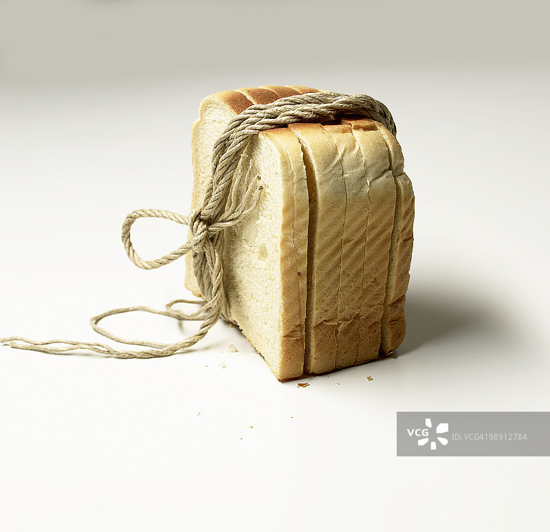 用绳子捆在一起的白面包片特写图片素材