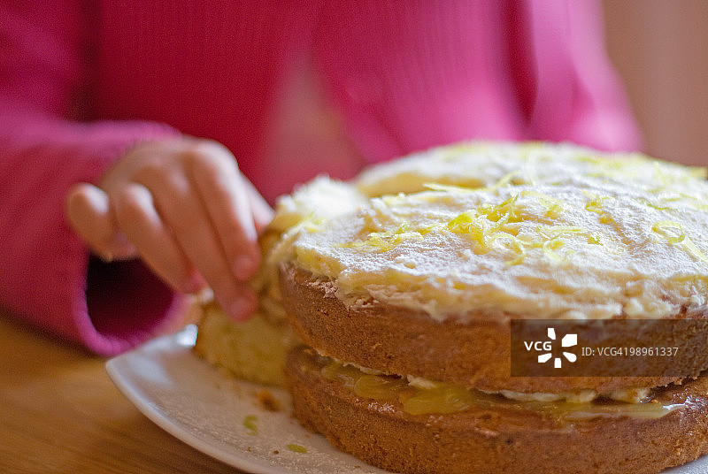 女孩拿着一片自制柠檬海绵蛋糕图片素材