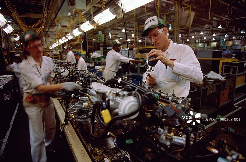 汽车发动机装配线，工人调整发动机缸体气门图片素材