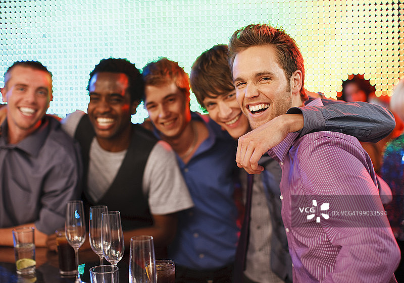 在酒吧微笑的一群男性朋友图片素材