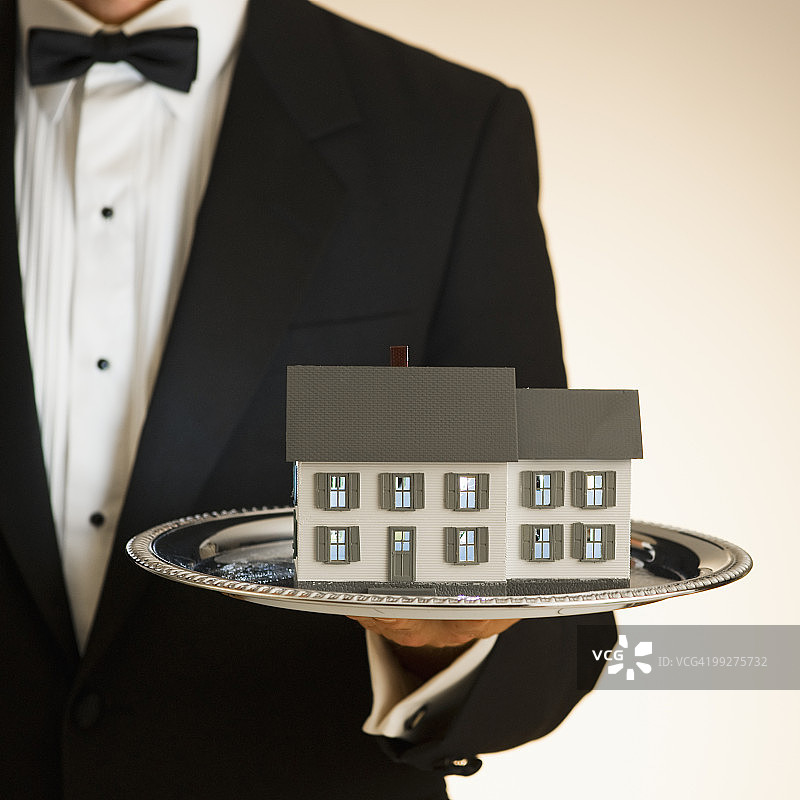 管家托盘上拿着玩具屋图片素材
