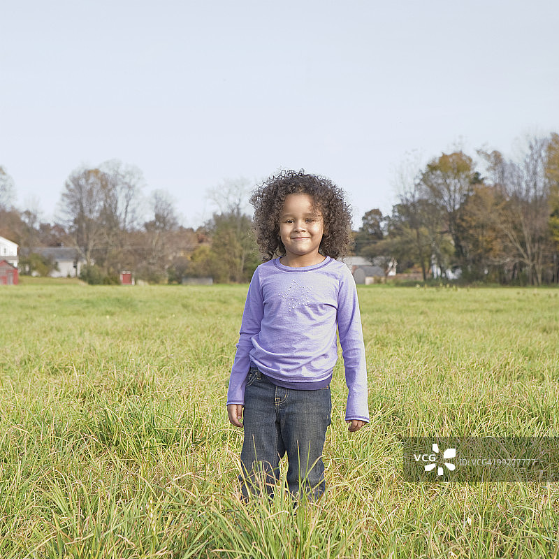站在草地上的年轻女孩图片素材