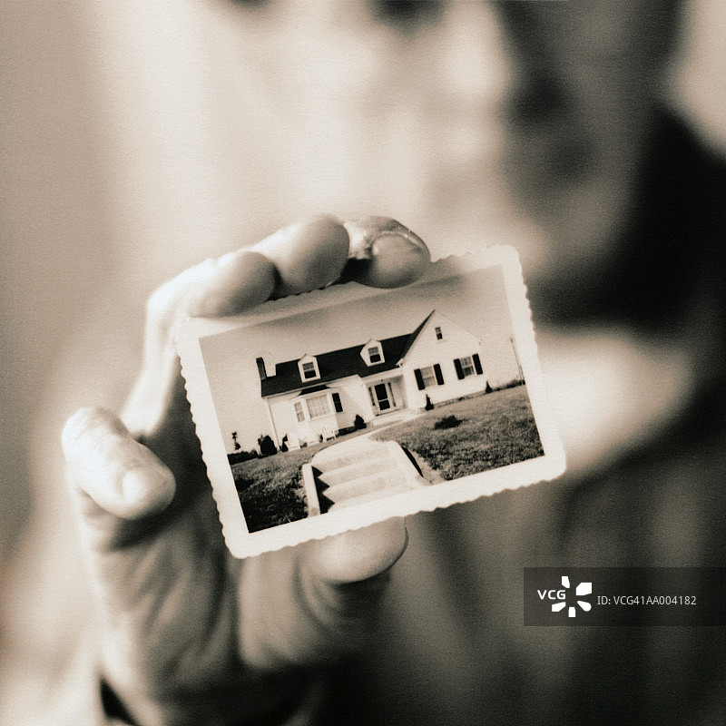 男子手持复古照片特写（焦点在照片上，黑白调）图片素材