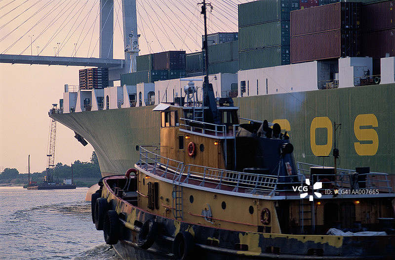 集装箱船旁的拖船图片素材