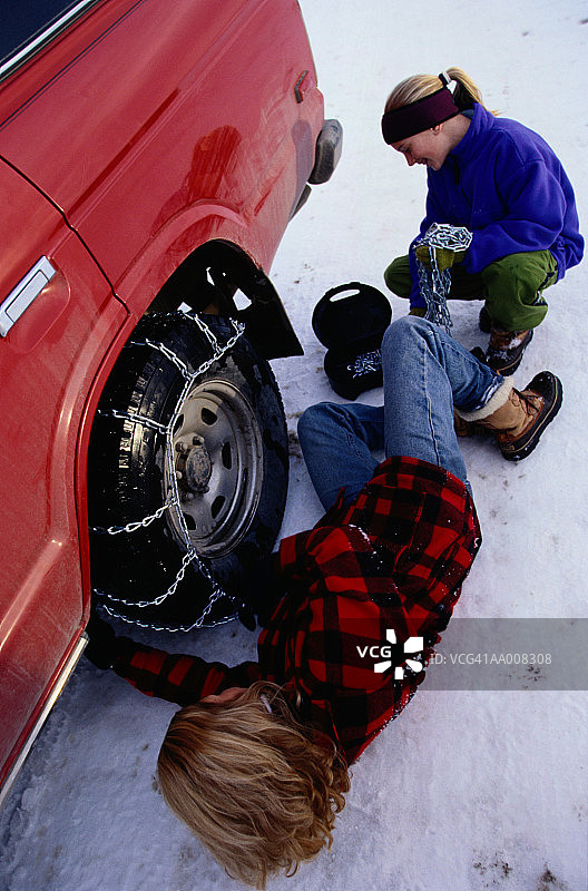 女人和女孩给汽车安装防滑链图片素材