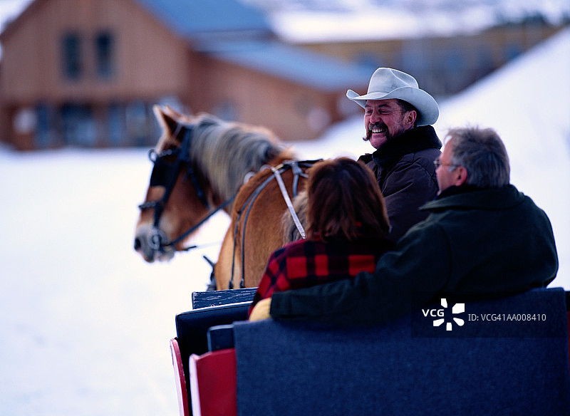 乘坐雪橇的夫妇，背影视角图片素材