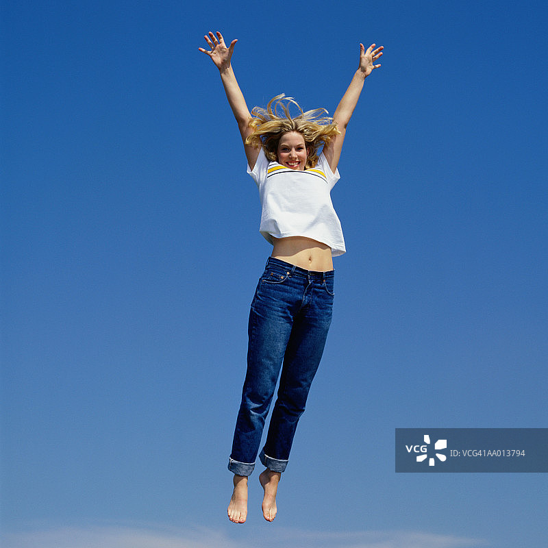 举起双臂跳跃的女人图片素材