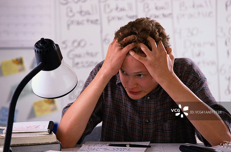 双手放在头发上的青少年男孩图片素材