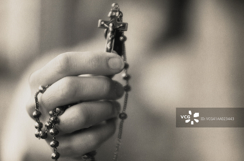 手持念珠上的十字架图片素材