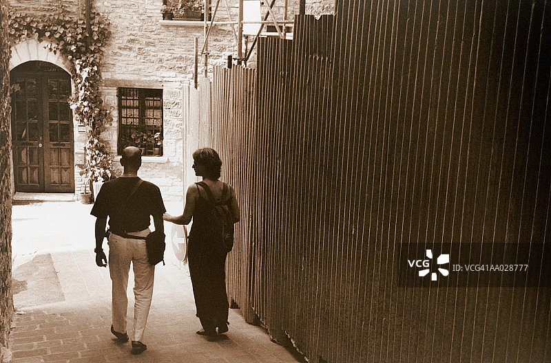 在小巷里行走的两个游客图片素材