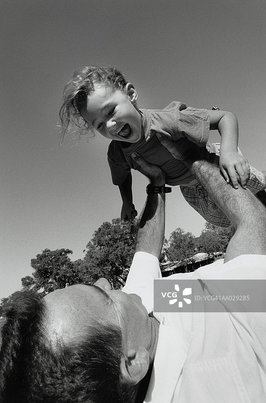 父亲和笑着的女儿玩耍图片素材