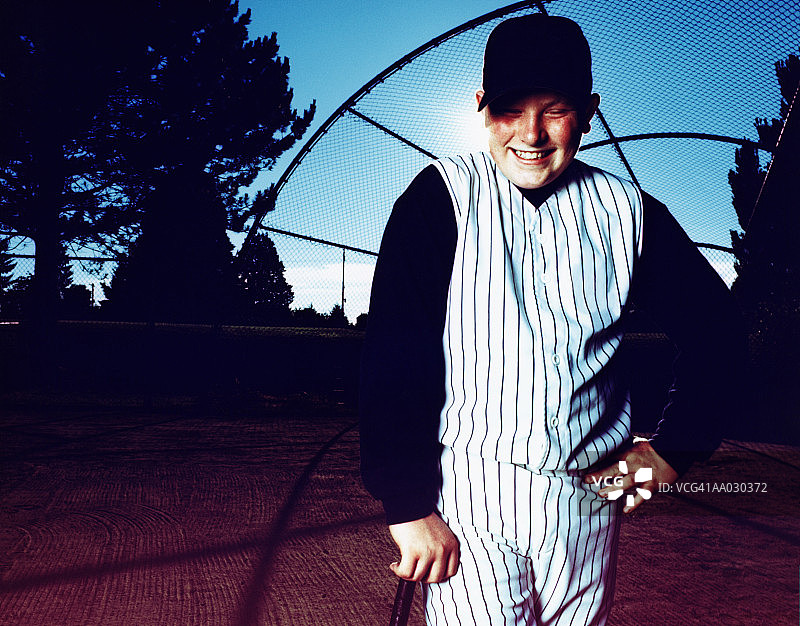 倚靠棒球棍的青少年男孩（11-13岁），肖像，高角度图片素材