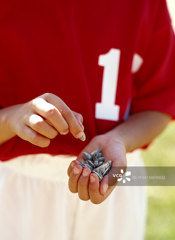 手持向日葵籽的棒球运动员图片素材