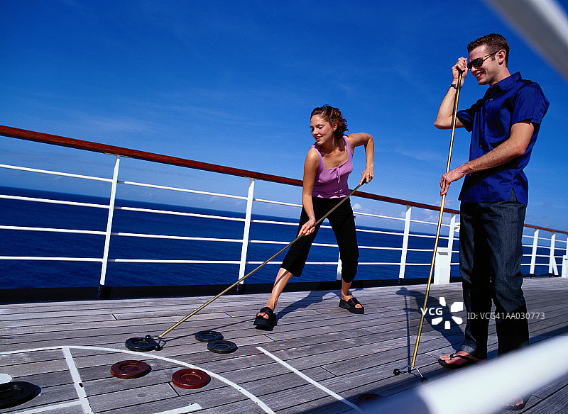 情侣在游轮上玩沙狐球图片素材