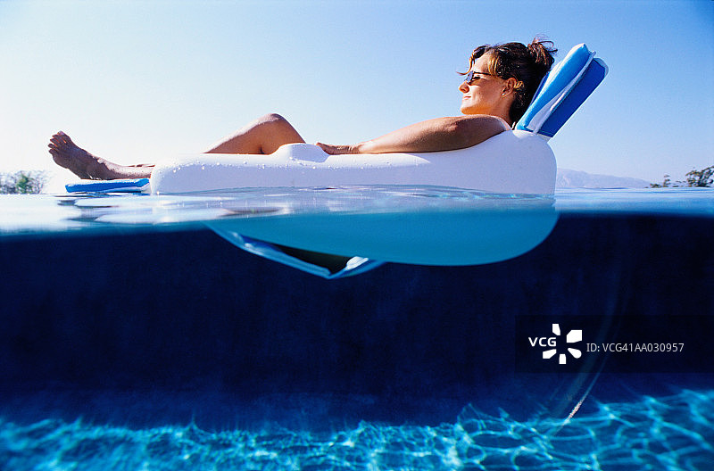 女人在漂浮椅上放松图片素材