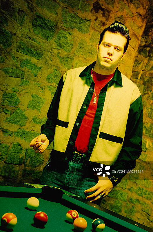 在台球桌旁抽烟的摇滚乐手图片素材