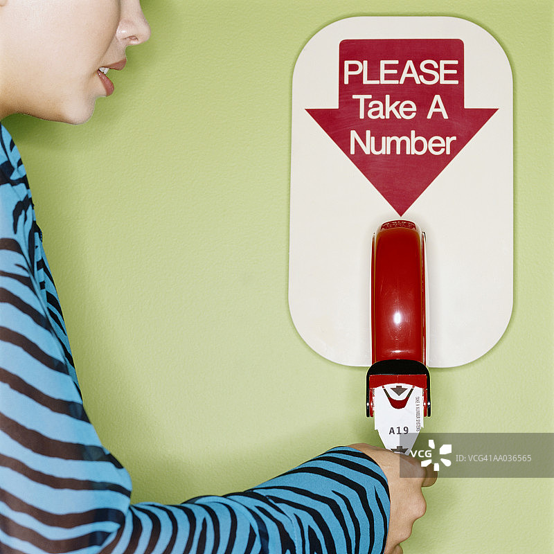 女人从号码分配器中取号，特写，侧视图图片素材
